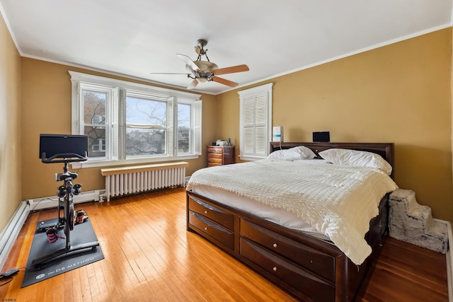 bedroom featuring light wood-type flooring, a ceiling fan, radiator, and crown molding