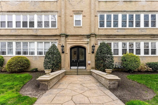 property entrance with brick siding and french doors