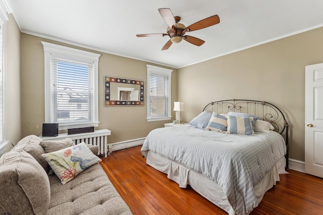bedroom featuring ornamental molding, baseboard heating, and hardwood / wood-style floors