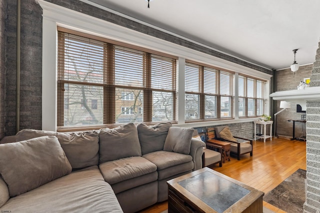 living area with a healthy amount of sunlight, a fireplace, and wood finished floors