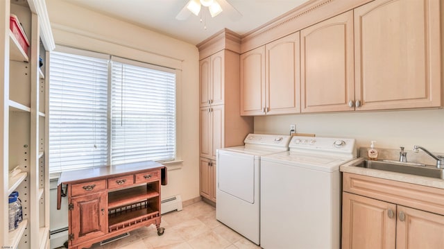clothes washing area with cabinet space, ceiling fan, a sink, baseboard heating, and washer and clothes dryer