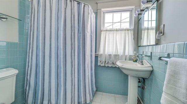full bathroom featuring wainscoting, toilet, tile walls, tile patterned floors, and a shower with curtain