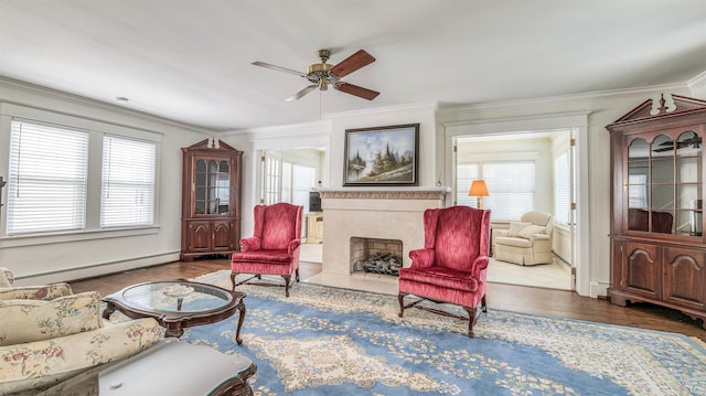 living room with crown molding, ceiling fan, plenty of natural light, and baseboard heating