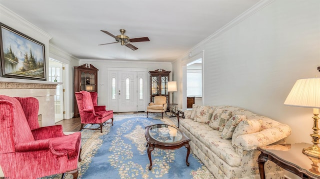 living area with crown molding, a ceiling fan, and wood finished floors