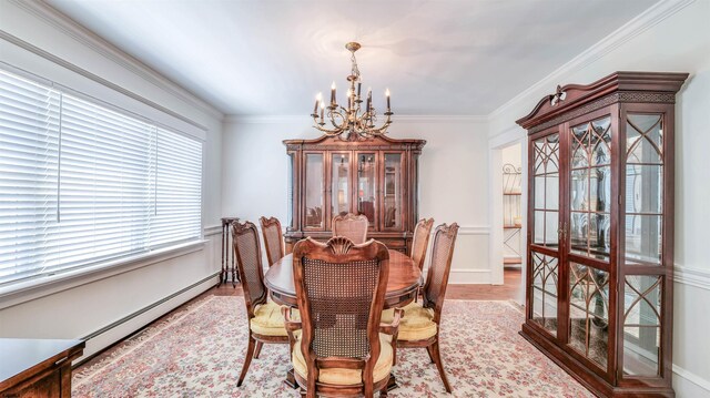 dining room with crown molding, a notable chandelier, baseboards, wood finished floors, and a baseboard heating unit