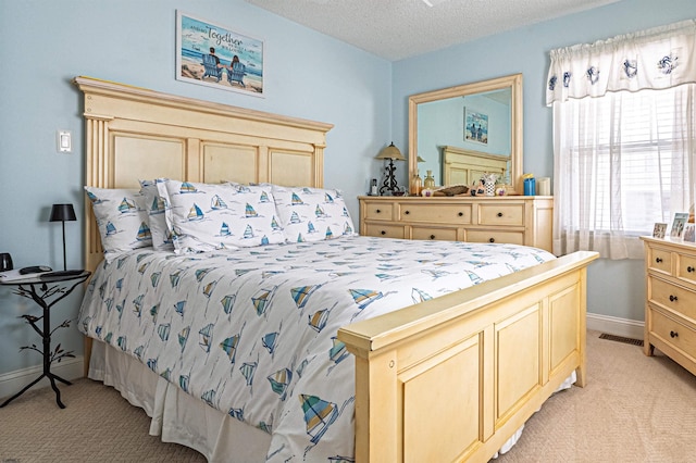 bedroom featuring baseboards, a textured ceiling, visible vents, and light carpet