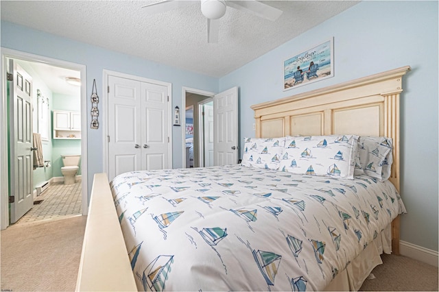 carpeted bedroom with connected bathroom, a textured ceiling, a ceiling fan, baseboards, and a closet