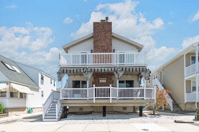 back of property featuring stairs, crawl space, and a chimney