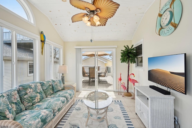 living area featuring baseboards, light tile patterned floors, lofted ceiling, and ceiling fan