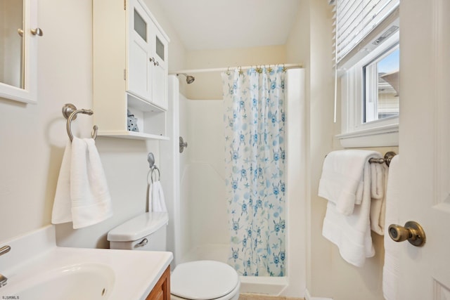 bathroom featuring vanity, toilet, and a stall shower