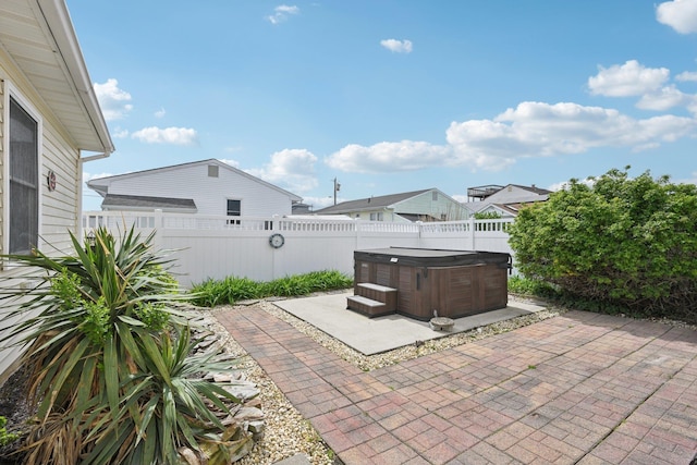 view of patio / terrace with a hot tub and a fenced backyard