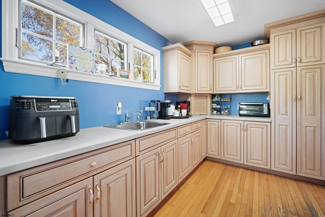 104 Van Sant Ave, Linwood, NJ 08221 - kitchen with a sink, light countertops, a toaster, light wood finished floors, and cream cabinetry