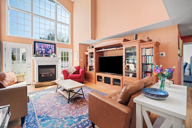 104 Van Sant Ave, Linwood, NJ 08221 - living room with a glass covered fireplace, a high ceiling, wood finished floors, and a healthy amount of sunlight