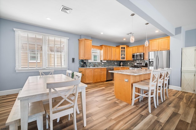 111 N Madison Ave Unit 2, Margate, NJ 08402 - kitchen featuring visible vents, light wood-style floors, a center island, tasteful backsplash, and appliances with stainless steel finishes