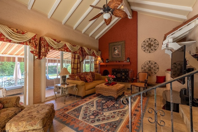 living room with vaulted ceiling with beams, ceiling fan, and a fireplace