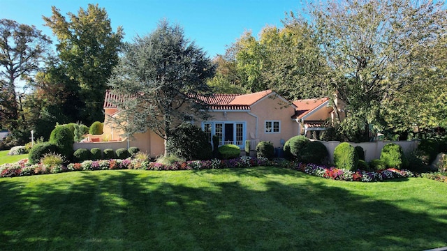 exterior space with a lawn, stucco siding, and a tiled roof