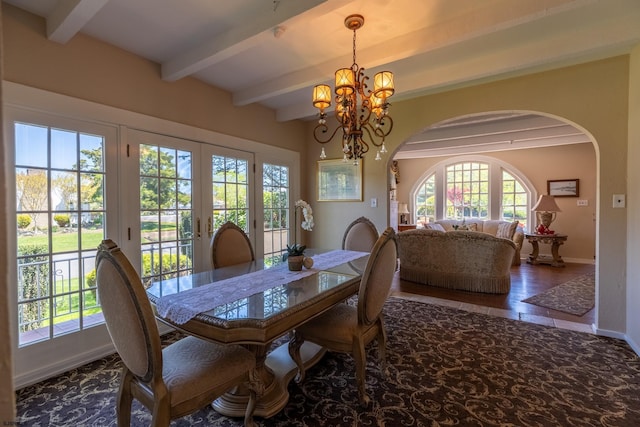 dining space featuring an inviting chandelier, beam ceiling, arched walkways, french doors, and baseboards