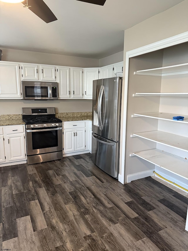 kitchen featuring light stone counters, dark wood-style flooring, appliances with stainless steel finishes, and white cabinetry