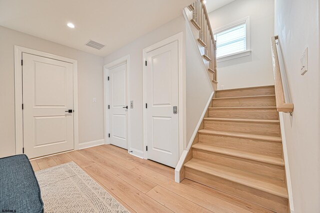 stairs featuring baseboards, recessed lighting, wood finished floors, and visible vents