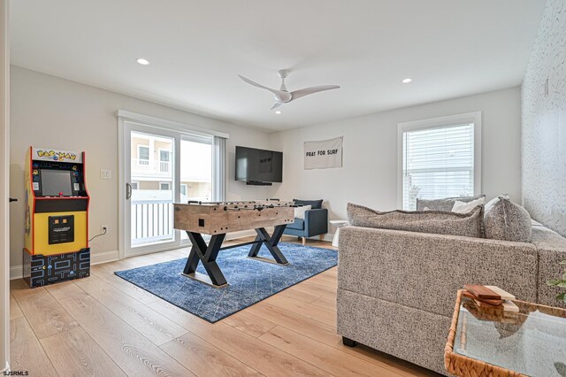 playroom featuring a ceiling fan, light wood-style flooring, and a wealth of natural light