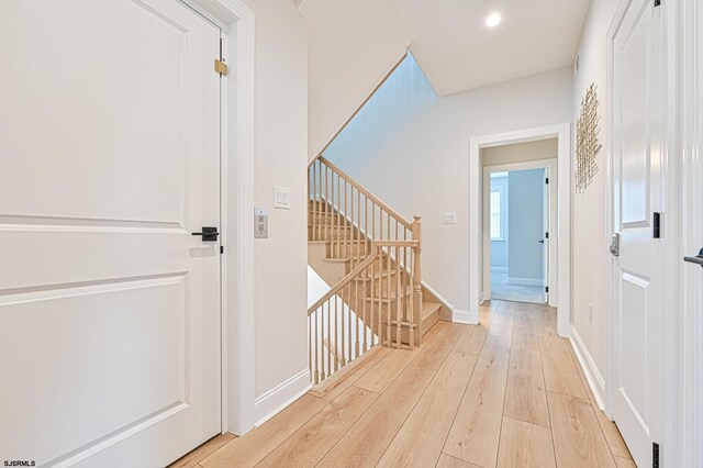 hallway featuring stairway, baseboards, recessed lighting, and light wood finished floors