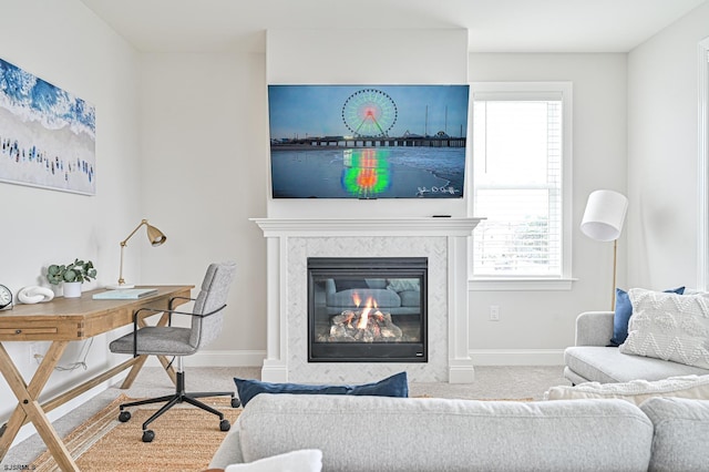 carpeted living area with baseboards and a fireplace