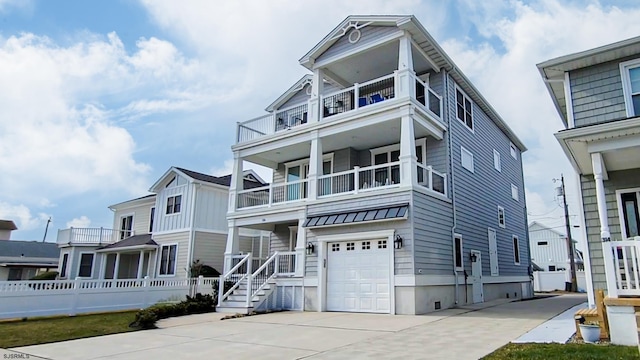 view of front of house featuring fence, an attached garage, concrete driveway, a balcony, and a standing seam roof