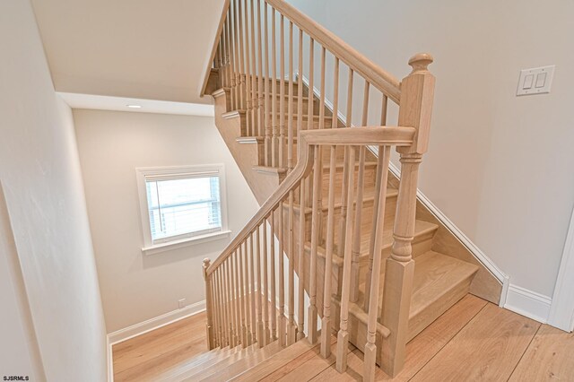 staircase featuring baseboards, recessed lighting, and wood finished floors