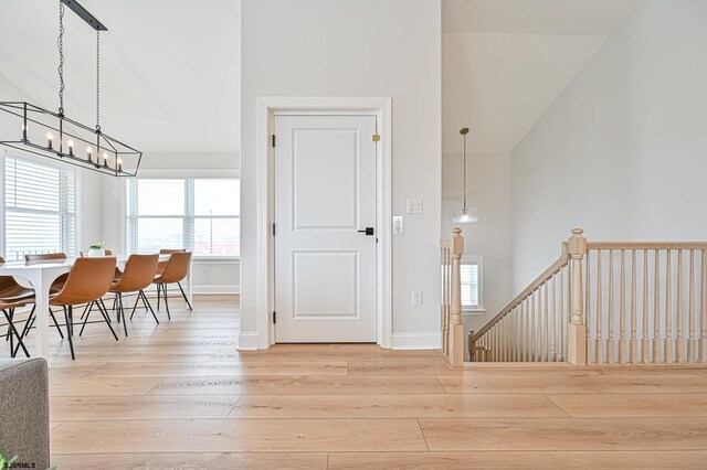 foyer with baseboards, lofted ceiling, and hardwood / wood-style floors