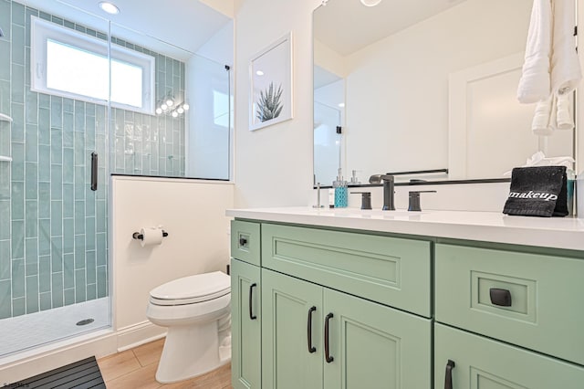 full bathroom with vanity, a shower stall, toilet, and wood finished floors
