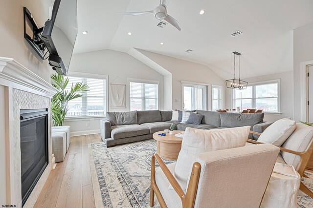 living room with plenty of natural light, lofted ceiling, visible vents, and a fireplace