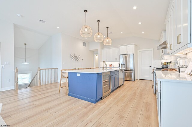 kitchen with visible vents, wine cooler, lofted ceiling, white cabinetry, and premium appliances
