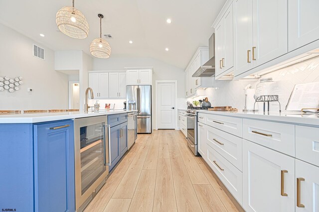 kitchen featuring appliances with stainless steel finishes, visible vents, blue cabinetry, wine cooler, and vaulted ceiling