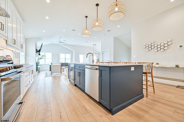 kitchen featuring appliances with stainless steel finishes, white cabinets, light wood finished floors, and recessed lighting
