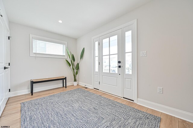 foyer with light wood-style floors, recessed lighting, and baseboards