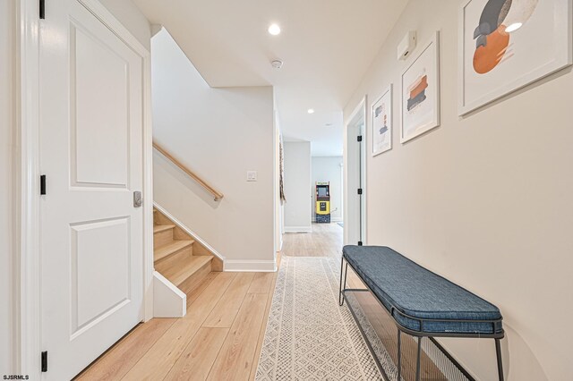 corridor with recessed lighting, baseboards, light wood-style flooring, and stairs
