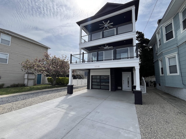 view of front facade featuring a ceiling fan, an attached garage, driveway, and a balcony