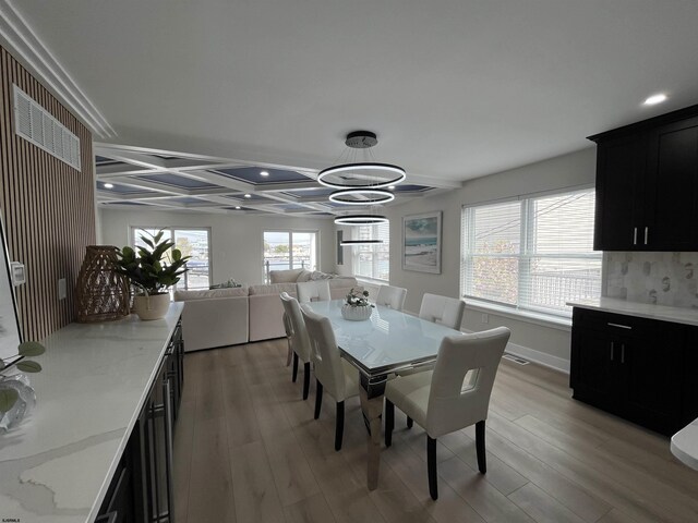 dining room featuring a healthy amount of sunlight, an inviting chandelier, and light wood-style floors