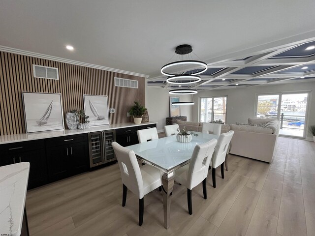 dining room with wine cooler, light wood-type flooring, a chandelier, and visible vents