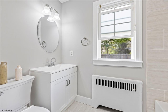 626 1st St, Northfield, NJ 08225 - bathroom featuring vanity, baseboards, radiator heating unit, and toilet