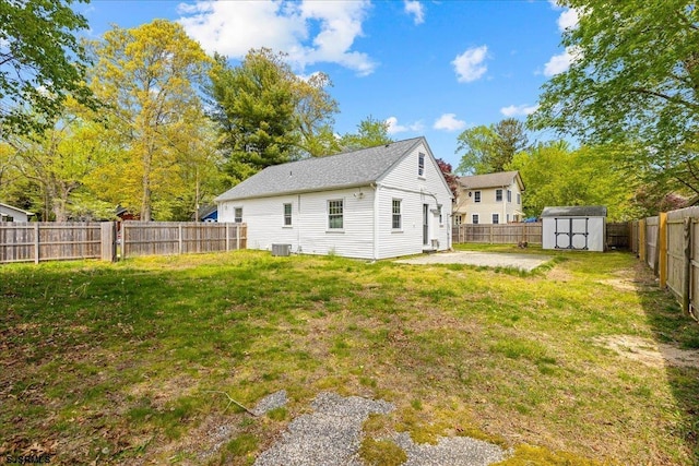 626 1st St, Northfield, NJ 08225 - rear view of house featuring a storage shed, a lawn, an outbuilding, central air condition unit, and a fenced backyard