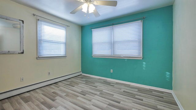 empty room with baseboards, baseboard heating, a ceiling fan, and wood finished floors