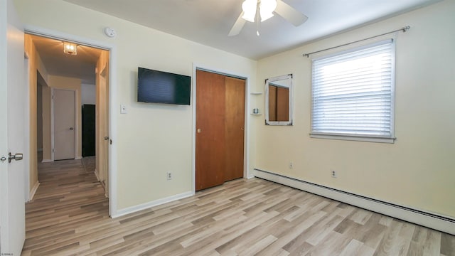empty room featuring baseboards, ceiling fan, a baseboard heating unit, and light wood-style flooring