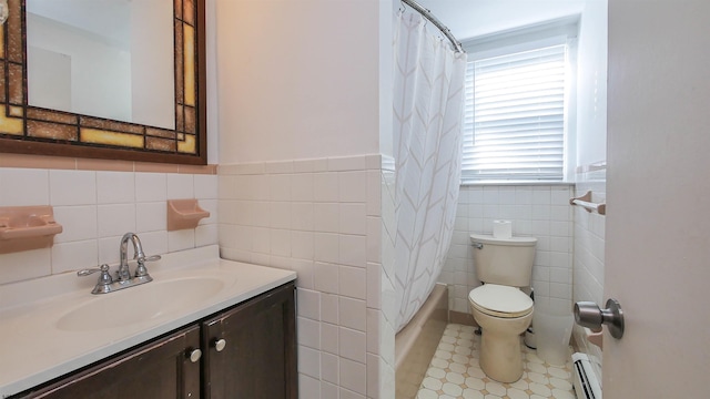 bathroom with vanity, wainscoting, toilet, tile walls, and a baseboard heating unit