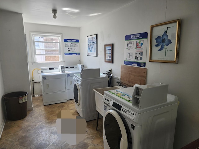 common laundry area featuring washer and dryer and stone finish flooring
