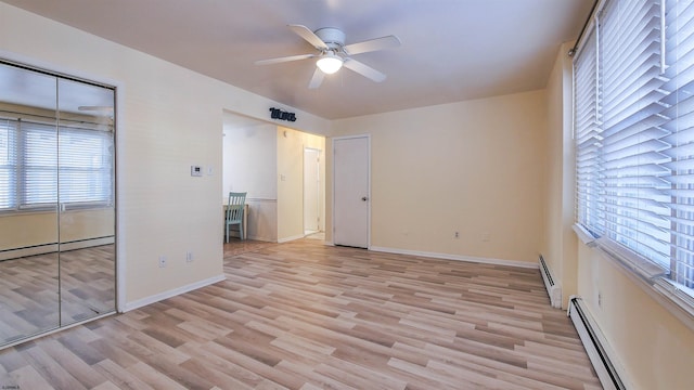 unfurnished bedroom featuring baseboard heating and multiple windows