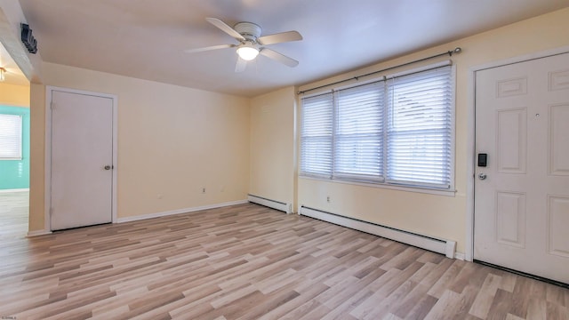 interior space featuring light wood-type flooring, a ceiling fan, plenty of natural light, and baseboard heating