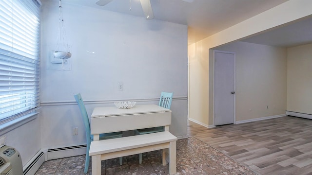 dining space with baseboards, a baseboard radiator, ceiling fan, and wood finished floors
