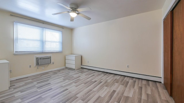 unfurnished bedroom with a closet, a wall mounted air conditioner, ceiling fan, baseboard heating, and light wood-style flooring