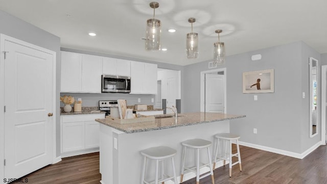 122 Hilton Ct, Egg Harbor Township, NJ 08234 - kitchen featuring stainless steel microwave, range, dark wood-style flooring, baseboards, and light stone countertops